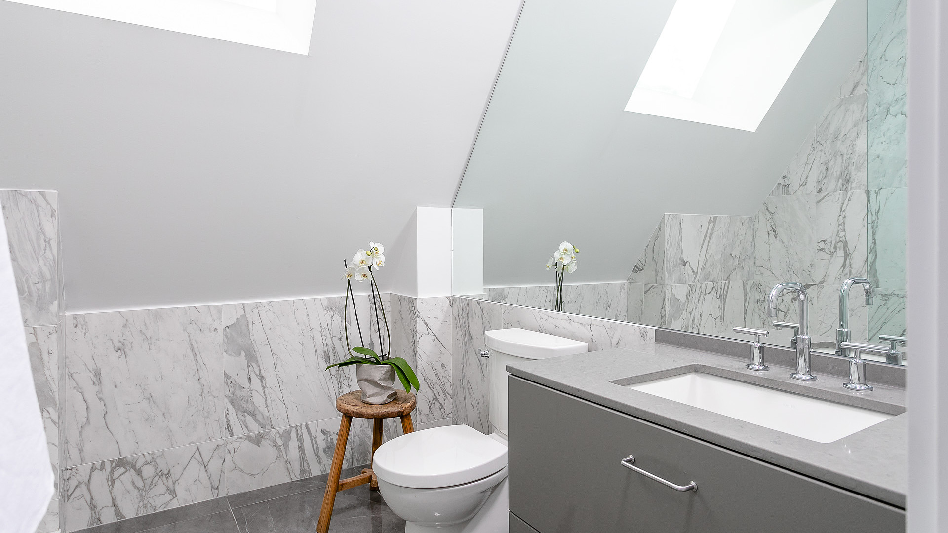 Marble bathroom with skylight and wall-mounted vanity