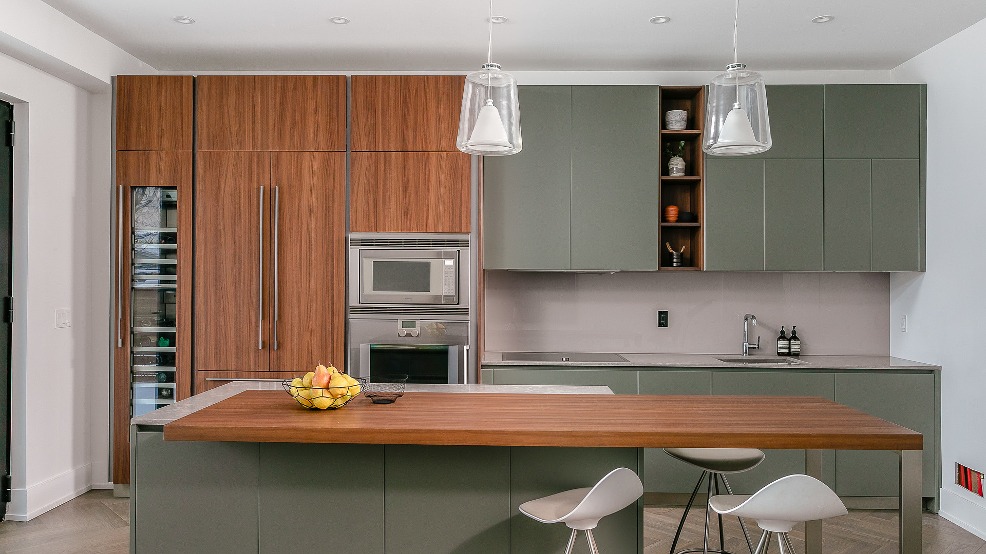 Sage and walnut kitchen with pendant lights and wine fridge