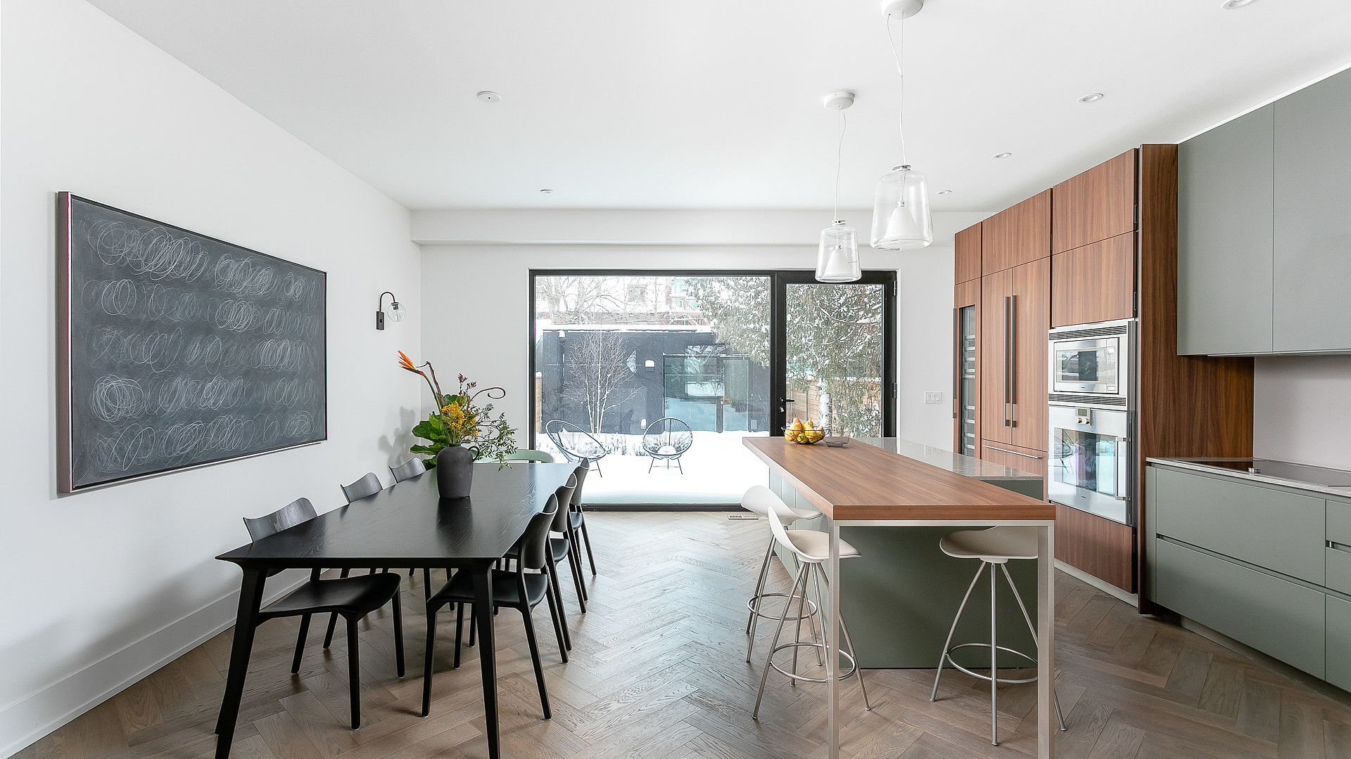 Custom kitchen with sage cabinetry, walnut island, and dining area
