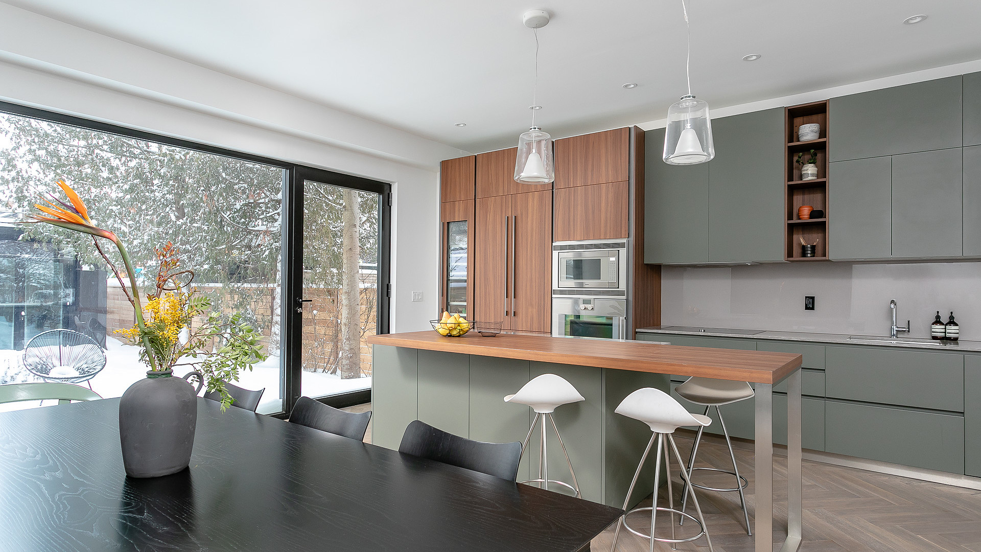 Open-concept kitchen with sage cabinetry and sliding patio doors