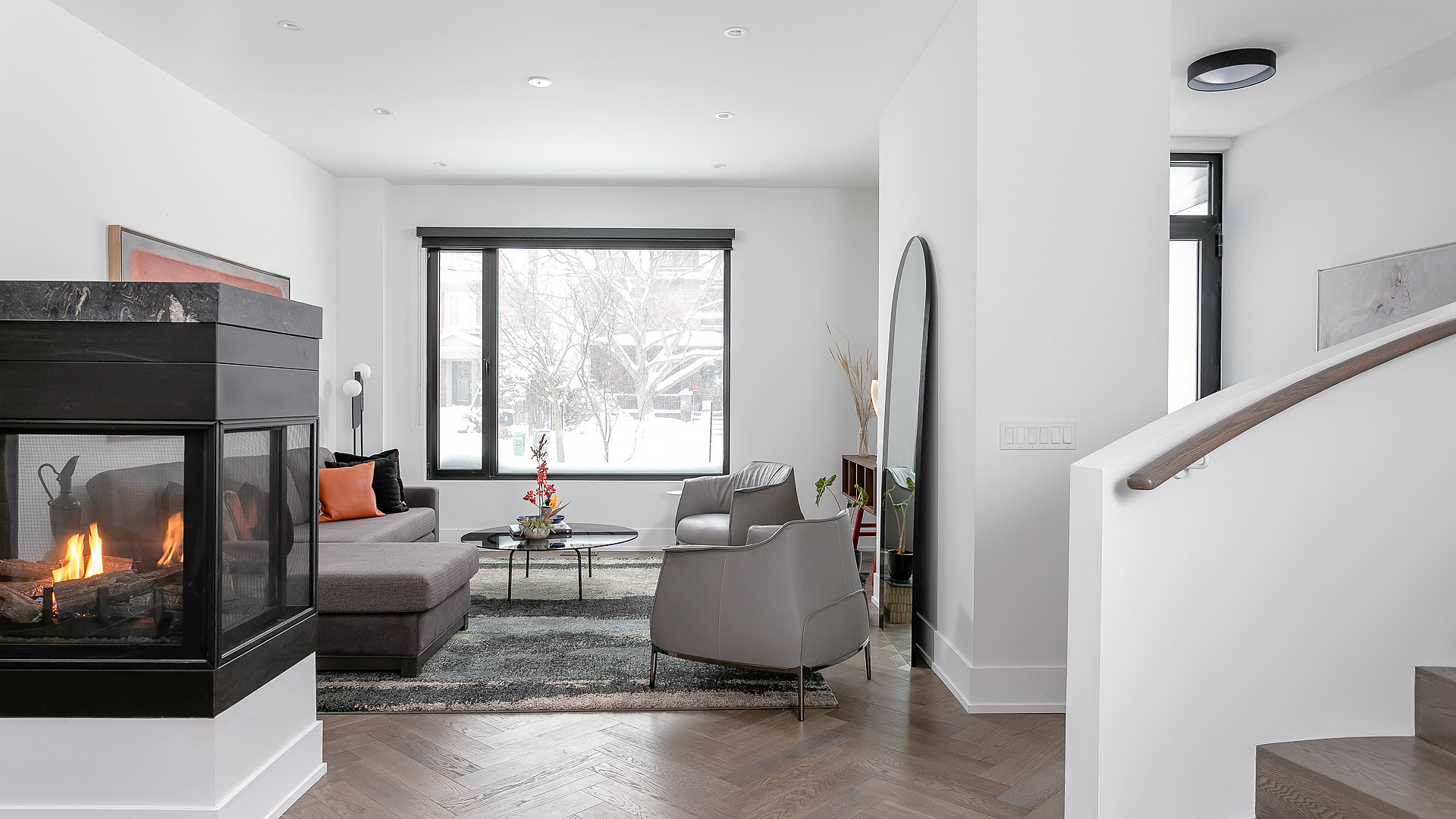 Living room with herringbone floors and three-sided fireplace