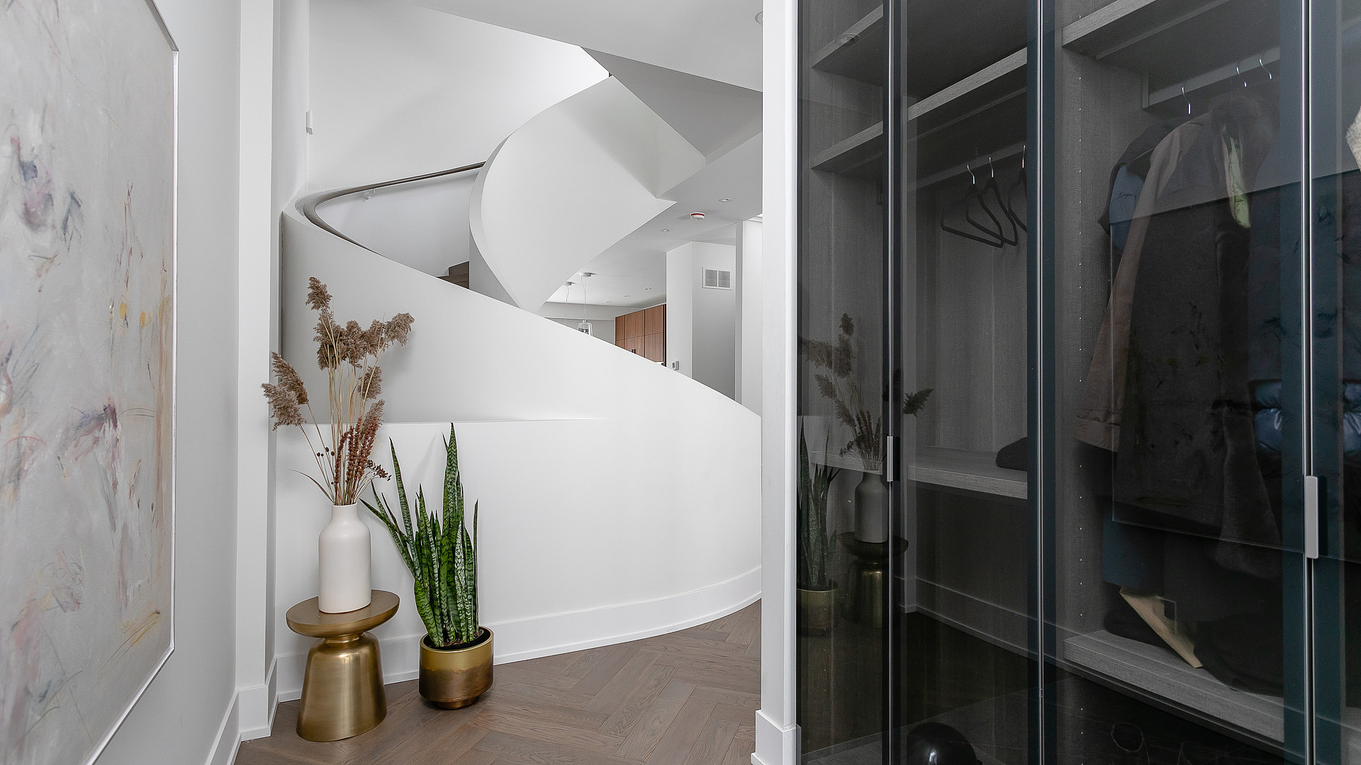 Entry with spiral staircase and glass closet display