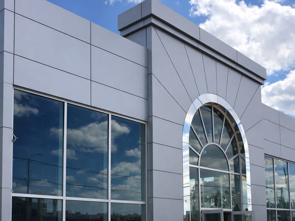 Finished commercial dealership with grey cladding and arched entrance