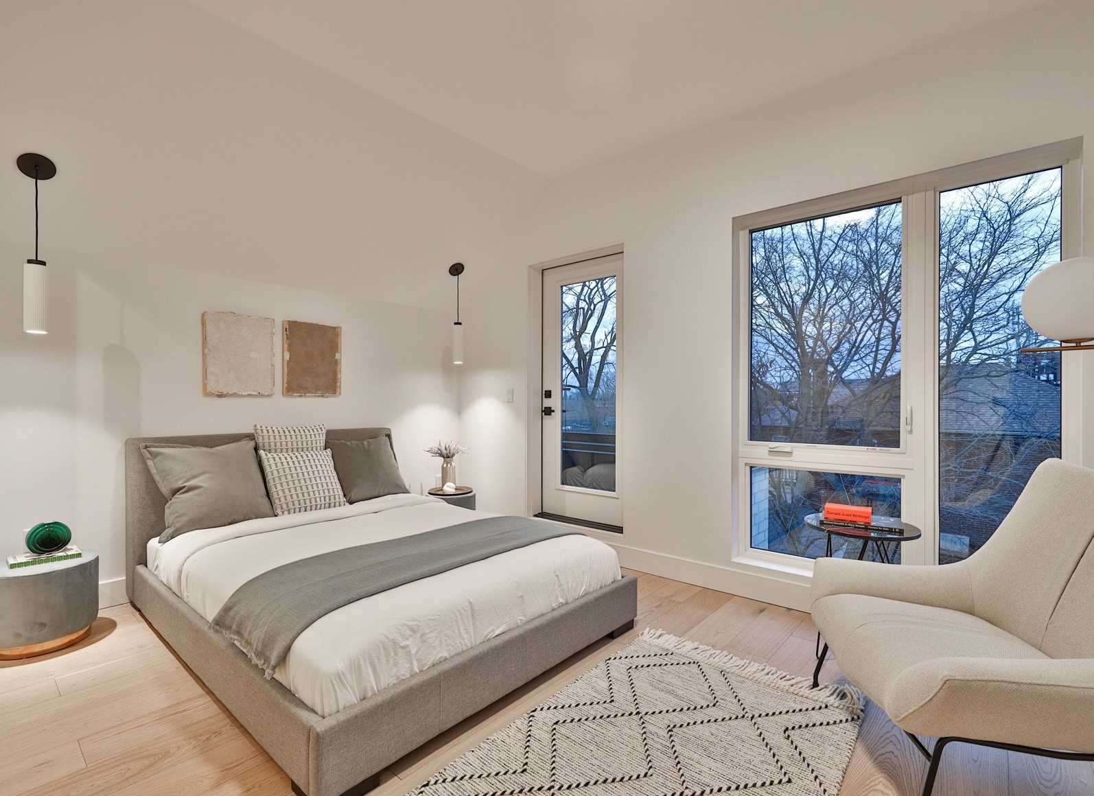 Bright primary suite with pendant lighting and balcony access