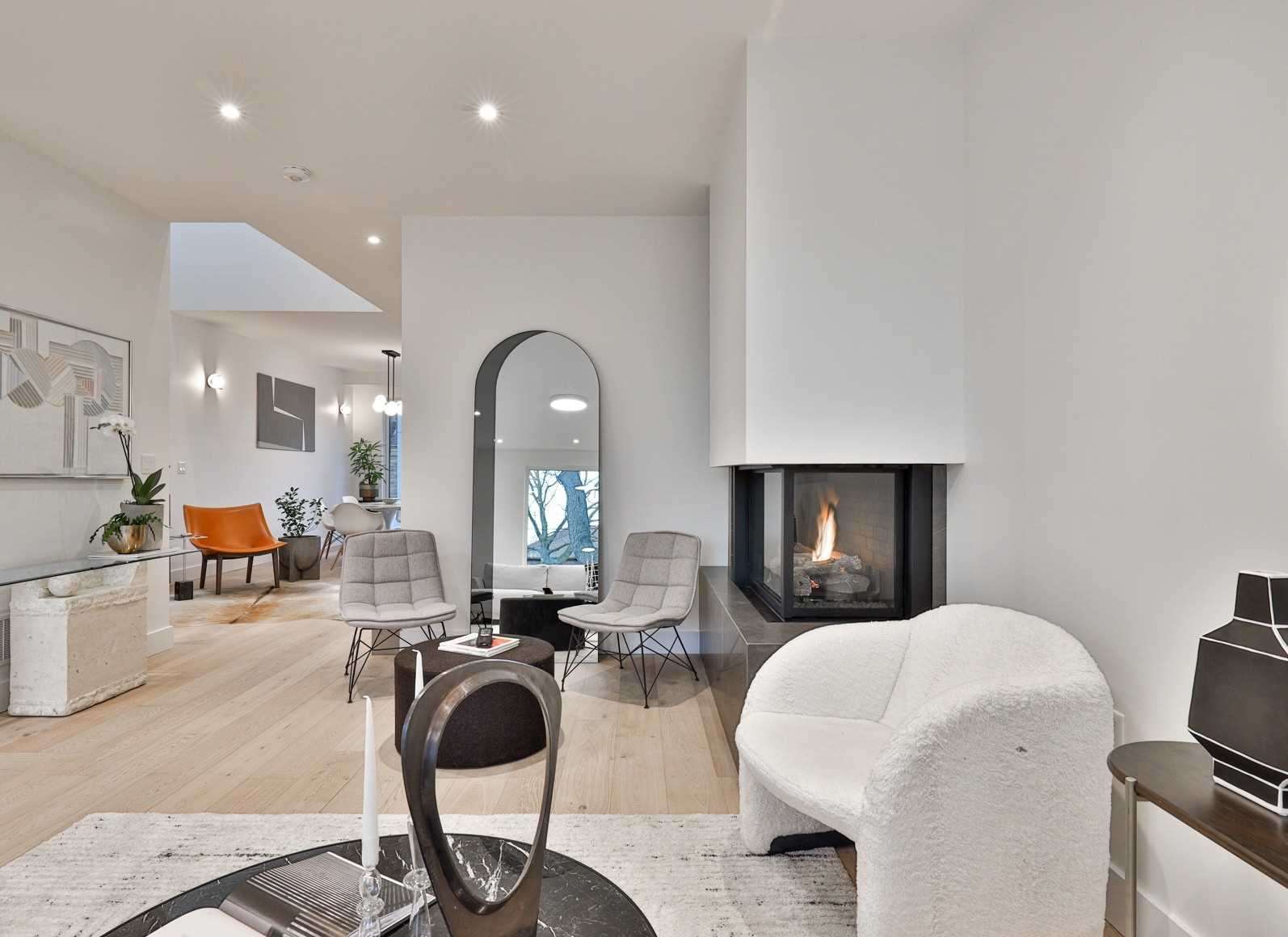 Modern open-concept living room with corner fireplace and arched doorway