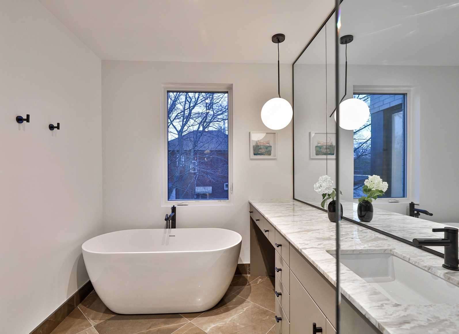 Spa bathroom with freestanding soaker tub and globe pendant light