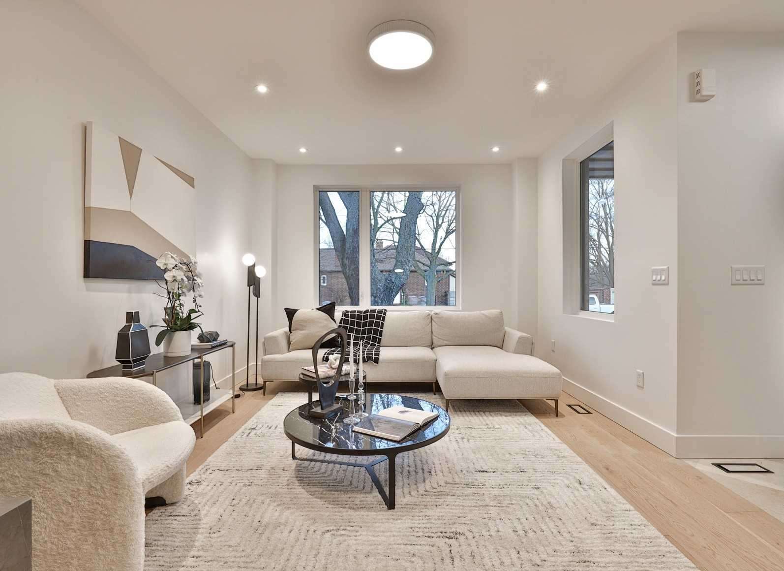 Bright modern living room renovation with white walls and oak floors